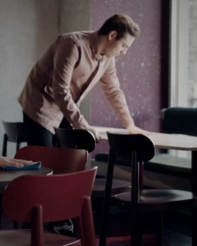 A staff member wiping a table after guests left