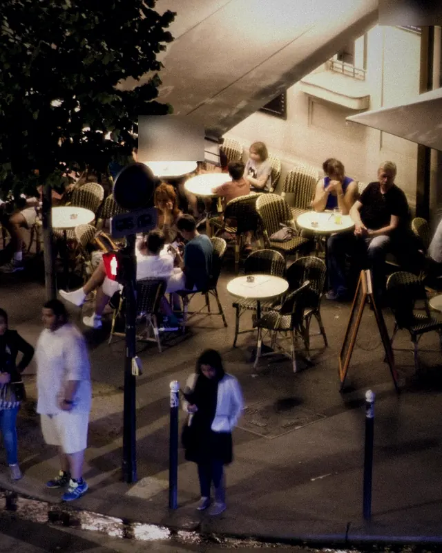 Night terrace and sidewalk with people waiting at the door
